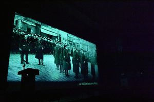 Ekran kinowy, na którym wyświetlany jest obraz przedstawiający historyczną policję