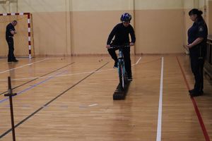 Zdjęcie przedstawia uczestnika turnieju pokonującego tor przeszkód na rowerze